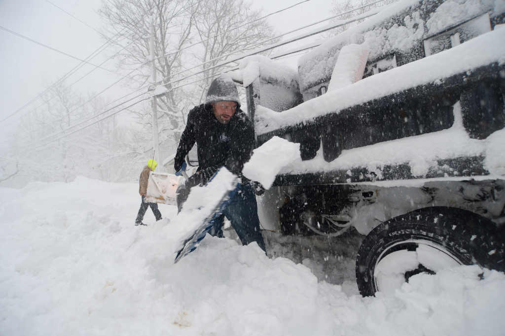 Bob Roesca helps dig out a plow after an intense lake-effect snowstorm impacted the area in Hamburg, New York, November 18, 2022. /CFP
