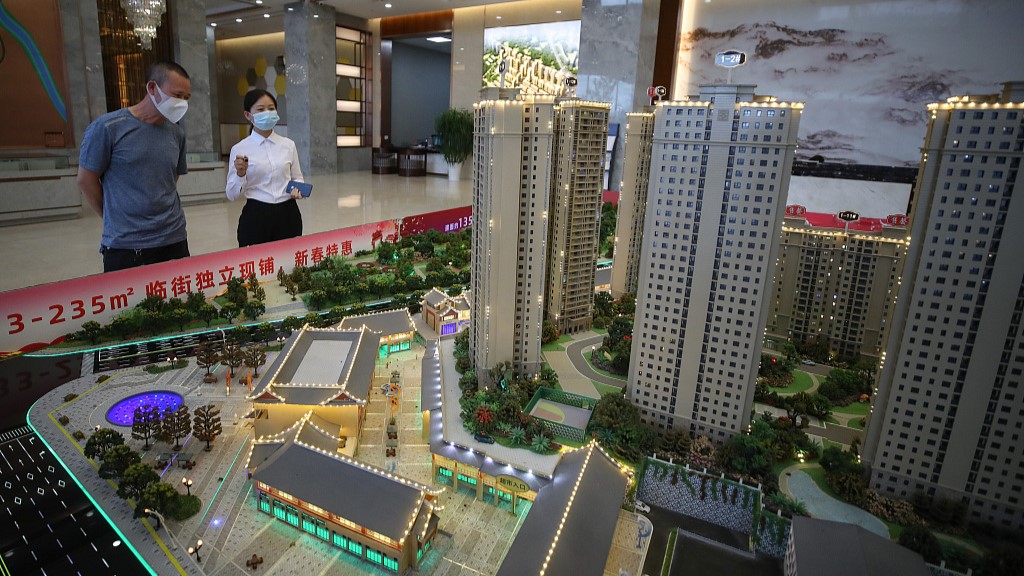 A sales person and a customer select residential housing units at a real estate sales department in southwest China's Guizhou Province, September 30, 2022. /CFP