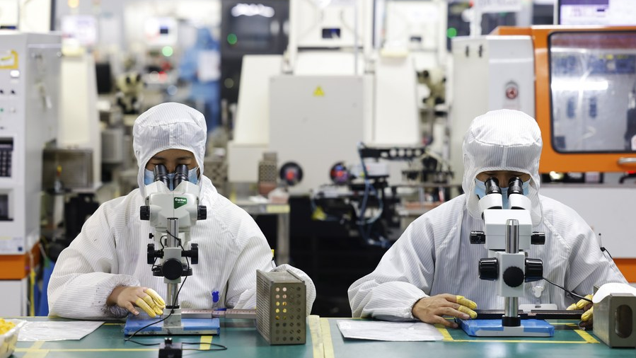 Workers make chips for export at an electronics company in Sihong, east China's Jiangsu Province, Feb. 23, 2022. /Xinhua