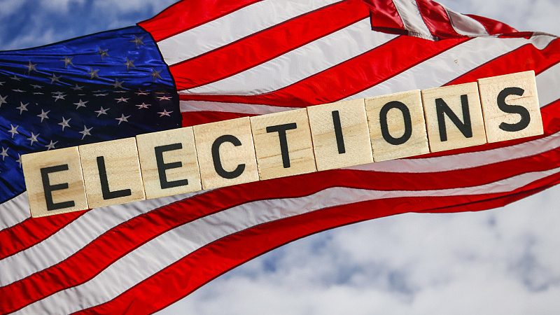 Word 'Elections' written with wood tile letters arranged on U.S. national flag background. /CFP