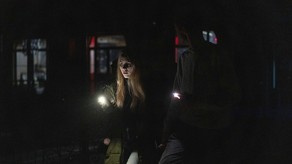 A young couple walk in the city center of Kyiv, which lost electrical power, Ukraine, November 24, 2022. /CFP