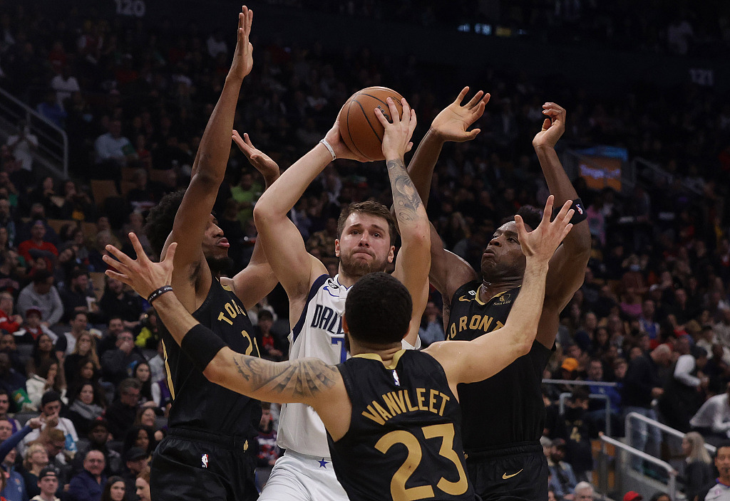 Luka Doncic (C) of the Dallas Mavericks is triple-teamed by Toronto Raptors defenders in the game at the Scotiabank Arena in Toronto, Canada, November 26, 2022. /CFP