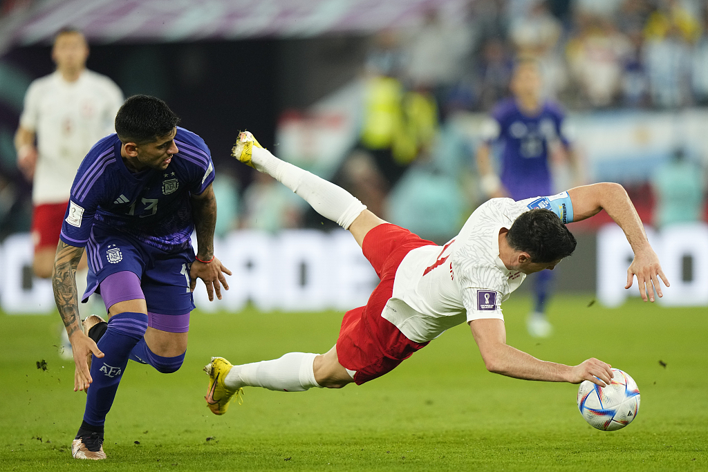 Robert Lewandowski (R) of Poland is foulded by Cristian Romero (L) of Argentina during their World Cup clash at Stadium 974 in Doha, Qatar, November 30, 2022. /CFP