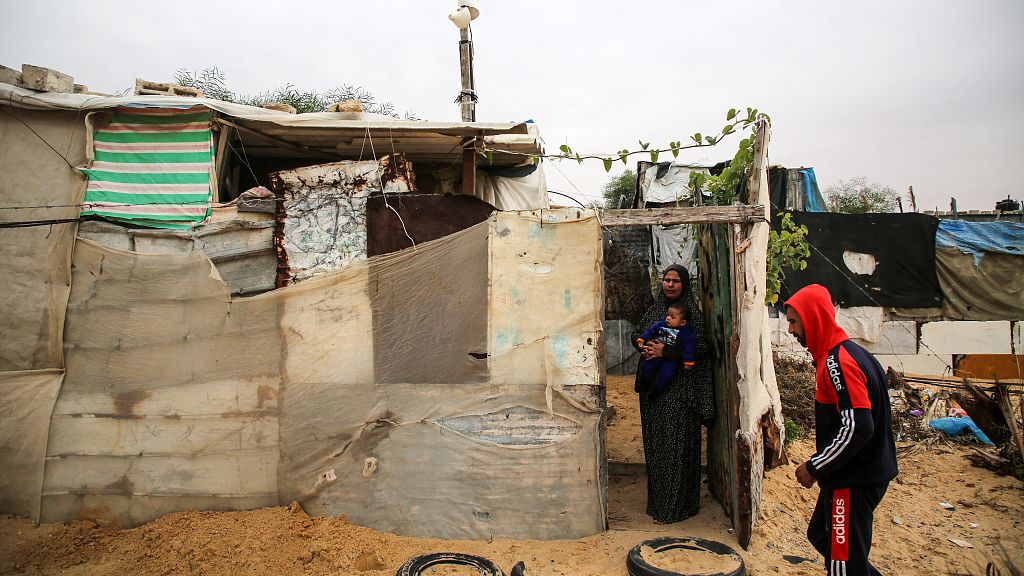 A Palestinian family stands in front of their house in the Nahr al-Bared camp in Khan Yunis in the southern Gaza Strip, November 28, 2022. /CFP