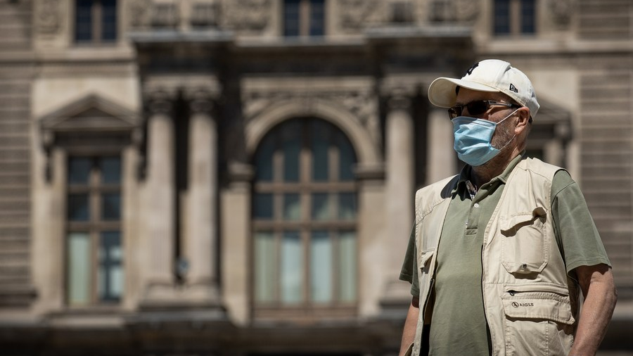 A man wearing a face mask walks in front of the Louvre Museum in Paris, France, July 8, 2022. /Xinhua