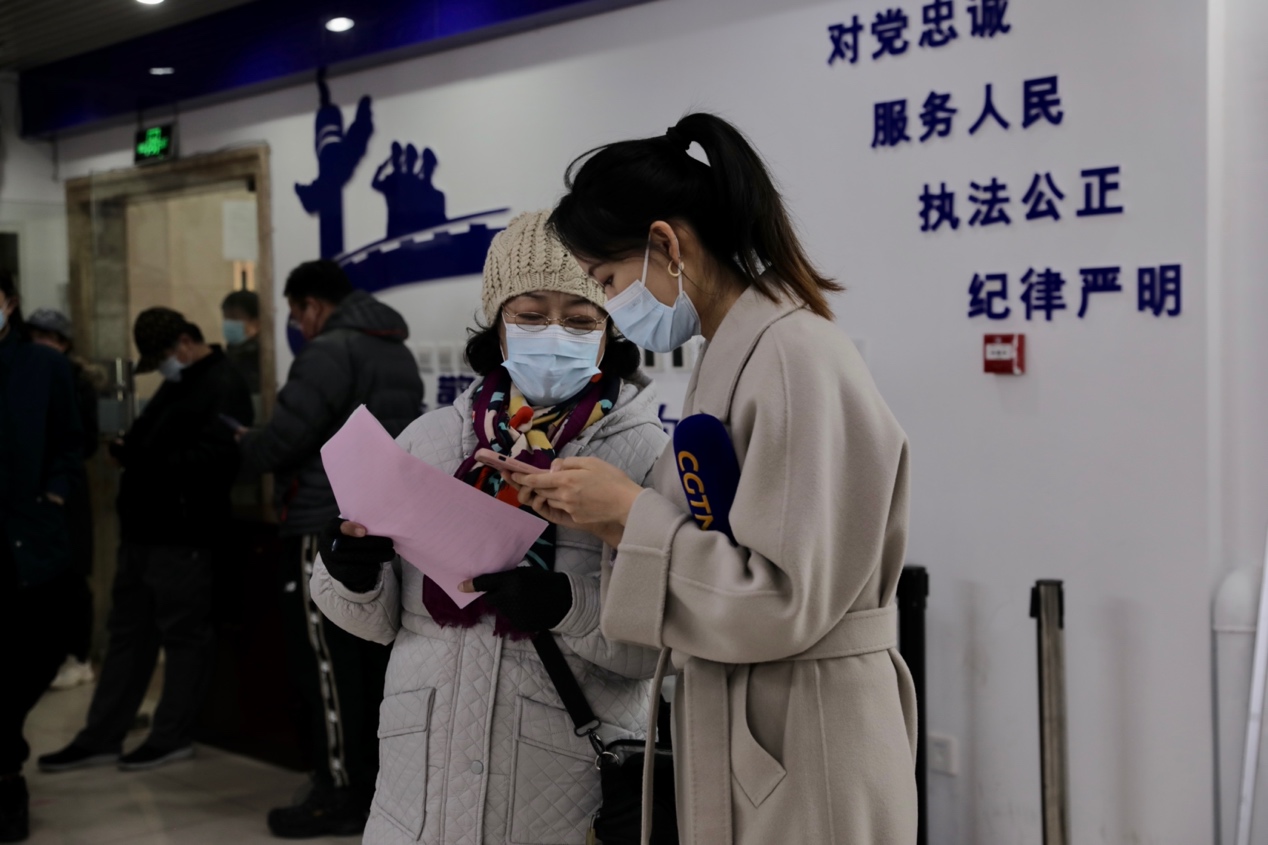 CGTN reporter Liu Jiaxin talks to a vaccine recipient. /Huayuanlu Street Media Center