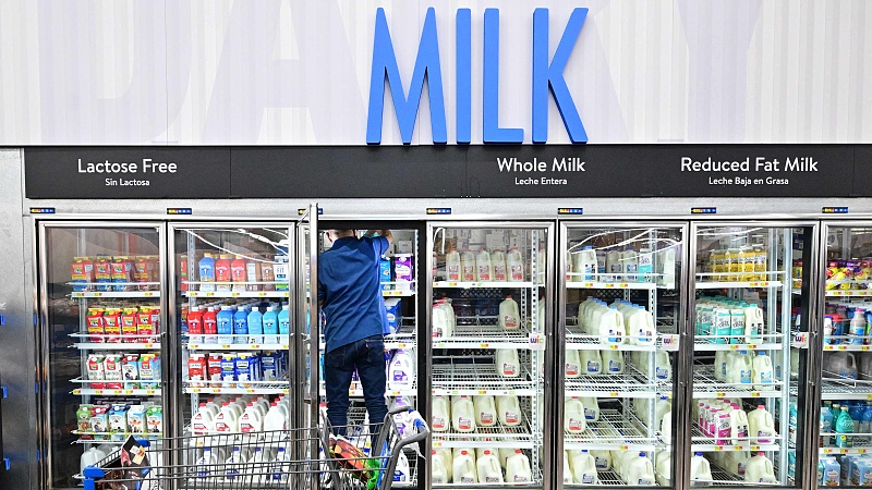 A man climbs into a fridge for milk at a Walmart store in Rosemead, California, U.S., on November 22, 2022. /CFP 