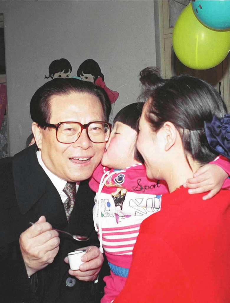 A girl at a Beijing kindergarten kisses Jiang Zemin after receiving polio immunization, December 5, 1993. /Xinhua