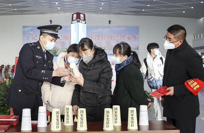 Passengers learn about the Constitution at a waiting hall in a station in Huai'an, east China's Jiangsu Province, December 2, 2022. /CFP
