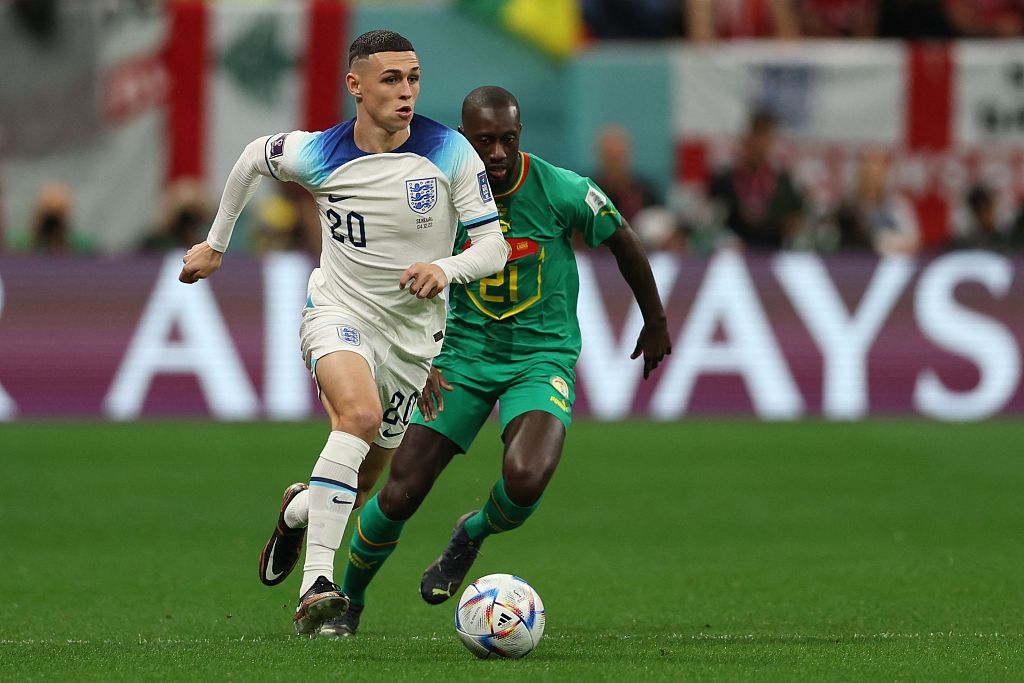 England playmaker Phil Foden (L) dribbles past Senegal defender Youssouf Sabaly during their World Cup clash at the Al-Bayt Stadium in Al Khor, Qatar, December 4, 2022. /CFP
