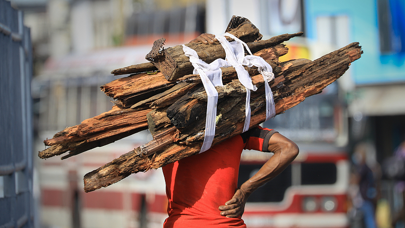 A Sri Lankan man carries wood in Colombo, Sri Lanka, June 29, 2022.