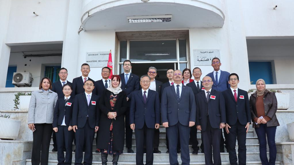 2022 年 12 月 5 日，突尼斯卫生部长 Ali Mrabet（前排右四）与第 26 批中国医疗队成员在突尼斯突尼斯市合影。/新华社