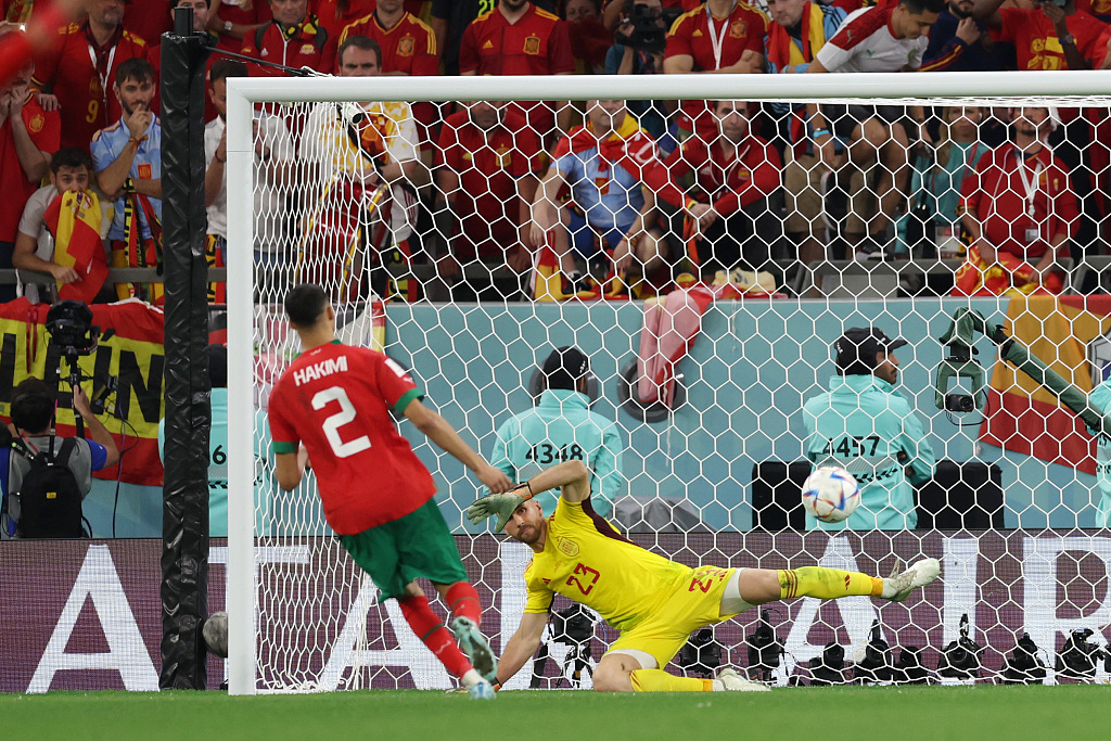 Achraf Hakimi (L) of Morocco scores the team's fourth and winning penalty past goalkeeper Unai Simon of Spain in the penalty shoot-out during their World Cup match at Education City Stadium in Al Rayyan, Qatar, December 6, 2022. /CFP