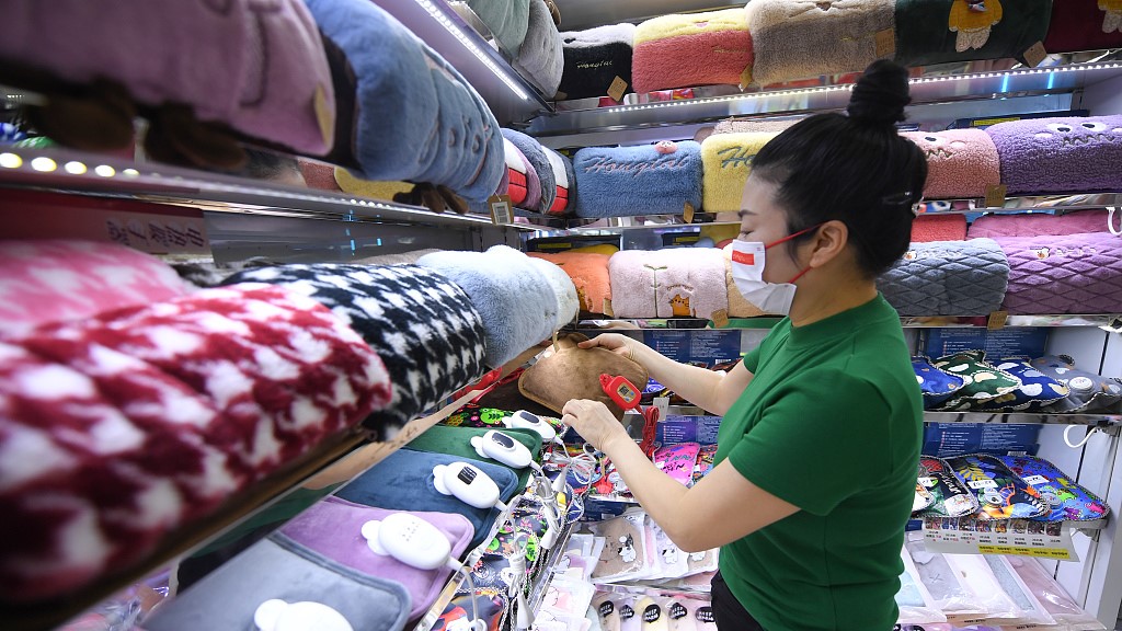 A store keeper sorts out the electric hot water bags for sale in Yiwu city in east China's Zhejiang Province, October 13, 2022. /CFP