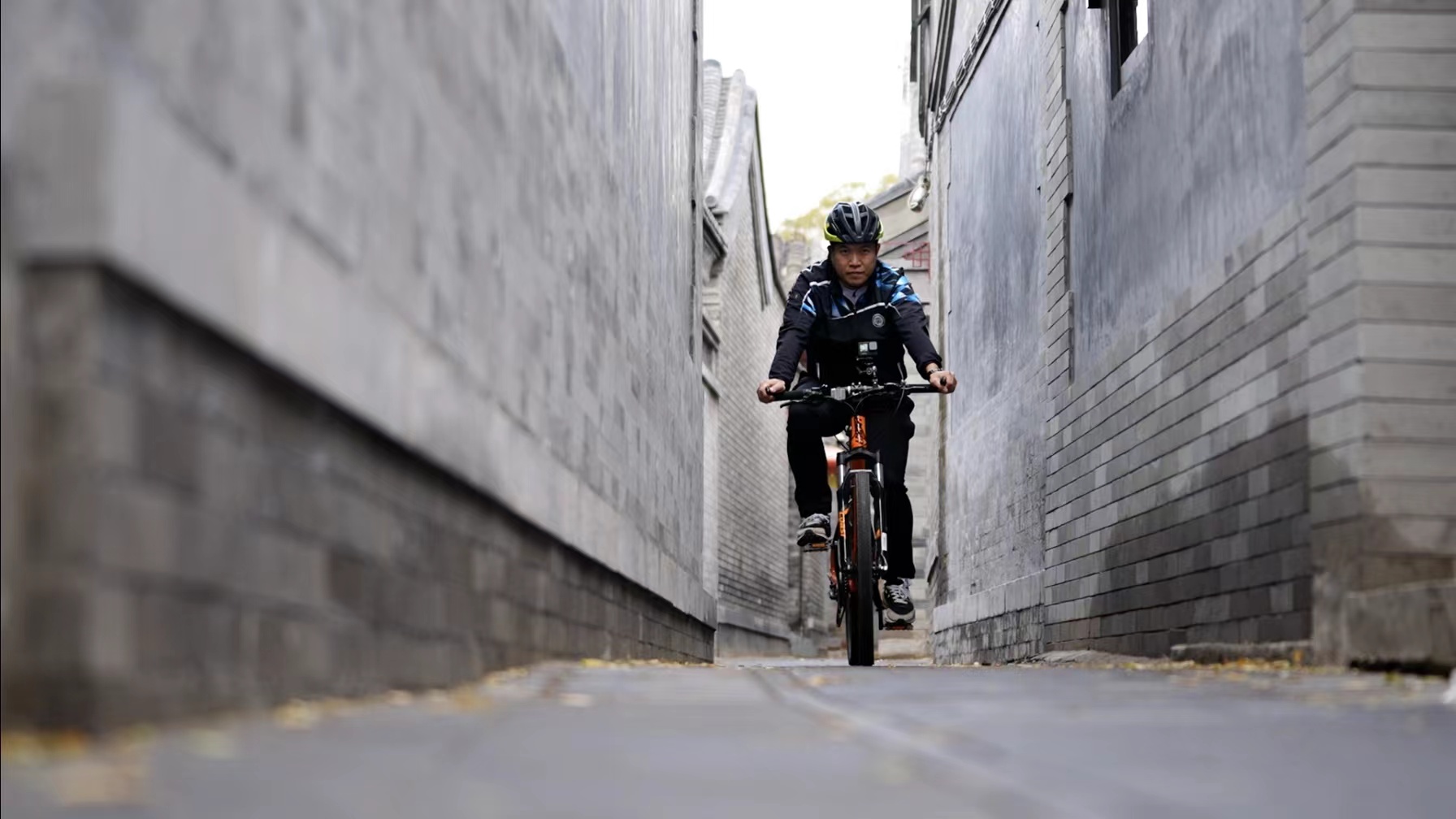 Chen Wencheng bikes in an alley, also known as a hutong, in Beijing, November 9, 2022. /CGTN