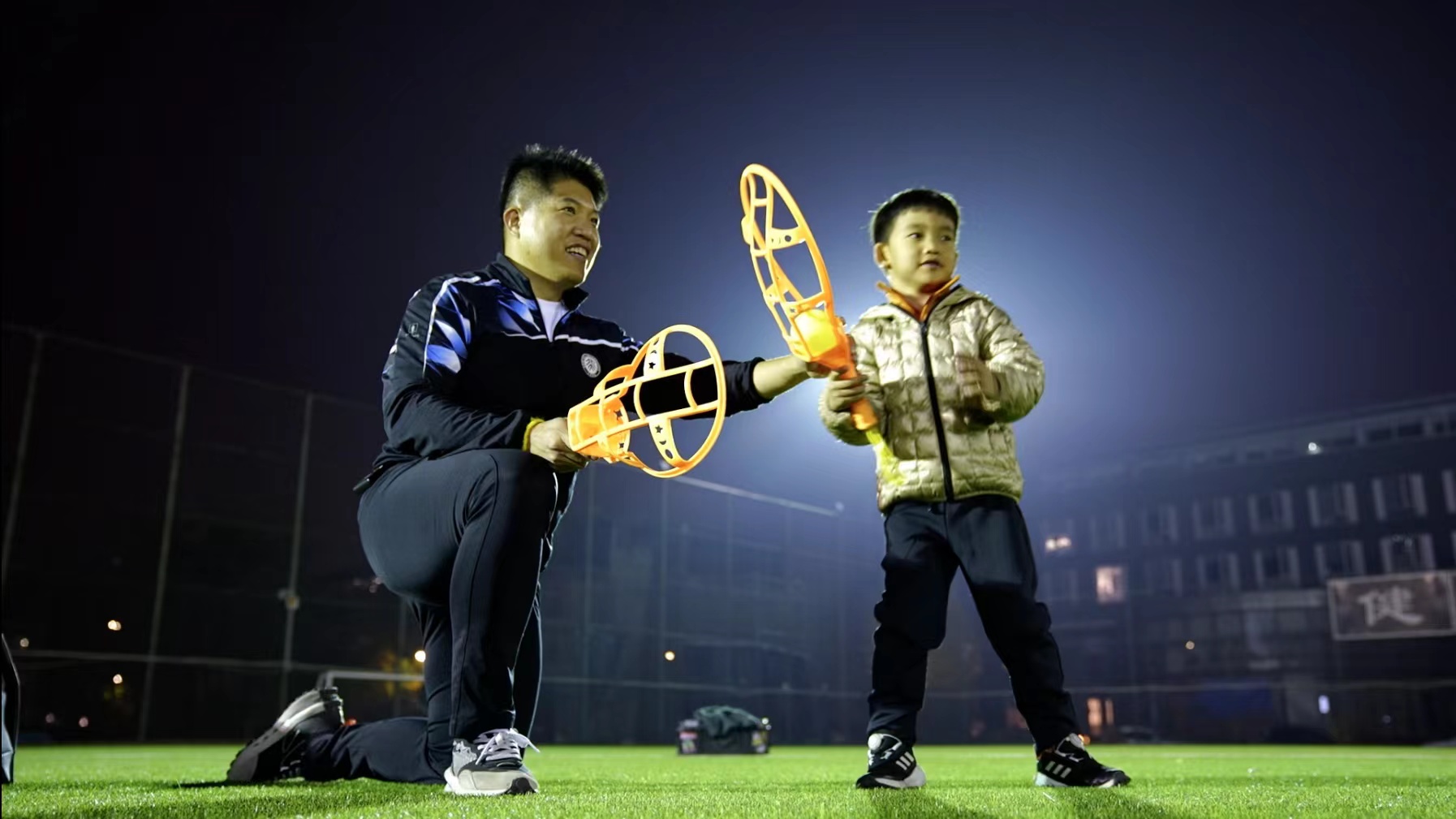 Chen Wencheng teaches a boy how to play skyball at a group tasting class on a playground at Peking University in Beijing, China, November 9, 2022. /CGTN