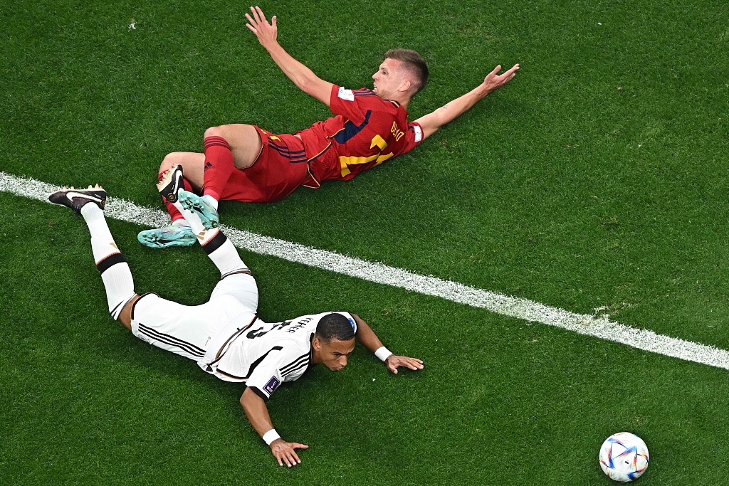 Spain's Dani Olmo and Germany's Thilo Kehrer (white) fall during their World Cup clash at the Al-Bayt Stadium in Al Khor, Qatar, November 27, 2022. /CFP