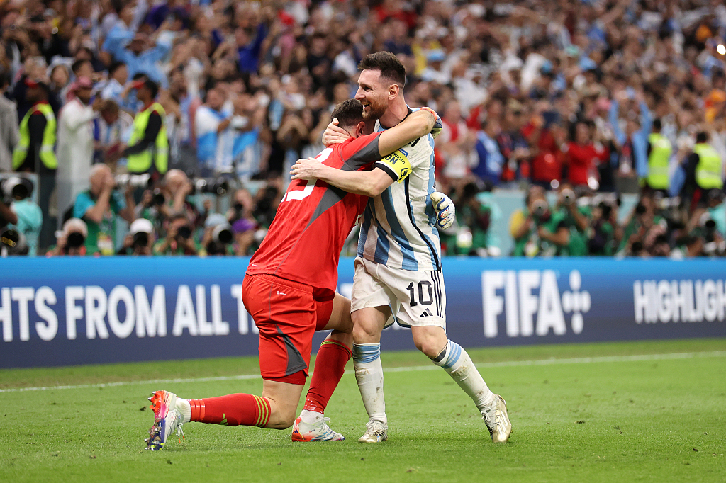 An emotional Emiliano Martinez (L) is embraced by Lionel Messi after their team, Argentina, beat the Netherlands on penalties in the World Cup quarterfinal round in Lusail City, Qatar, December 9, 2022. /CFP
