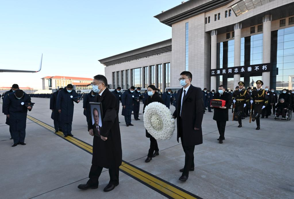 Jiang Zemin's family members holding Jiang's portrait, cinerary casket and a wreath walk towards a special plane at the Xijiao Airport in Beijing, capital of China, December 11, 2022. The ashes of beloved Comrade Jiang Zemin were scattered into the sea at the estuary of the Yangtze River on Sunday, in accordance with the wishes of Jiang himself and his family. /Xinhua