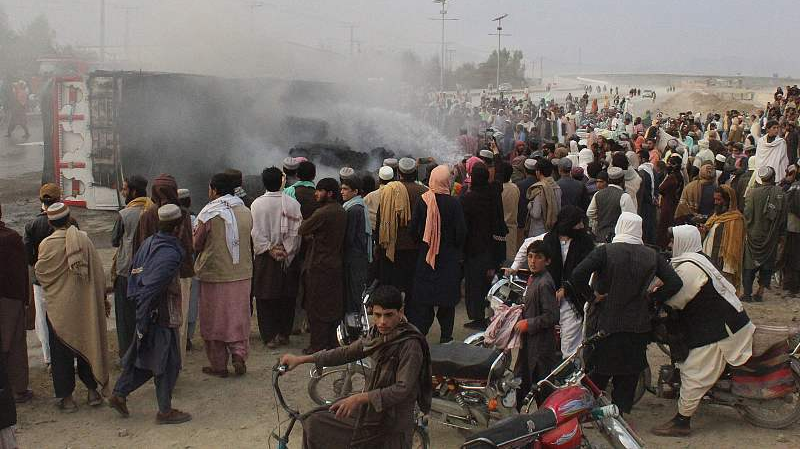 Residents gather around a burning truck after Taliban forces fired mortars at Pakistan's border town of Chaman, December 11, 2022. /CFP