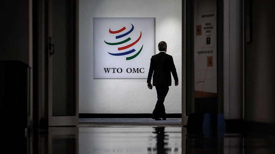 A man walks past a sign of the World Trade Organization at its headquarters in Geneva, Switzerland, June 12, 2022. /CFP