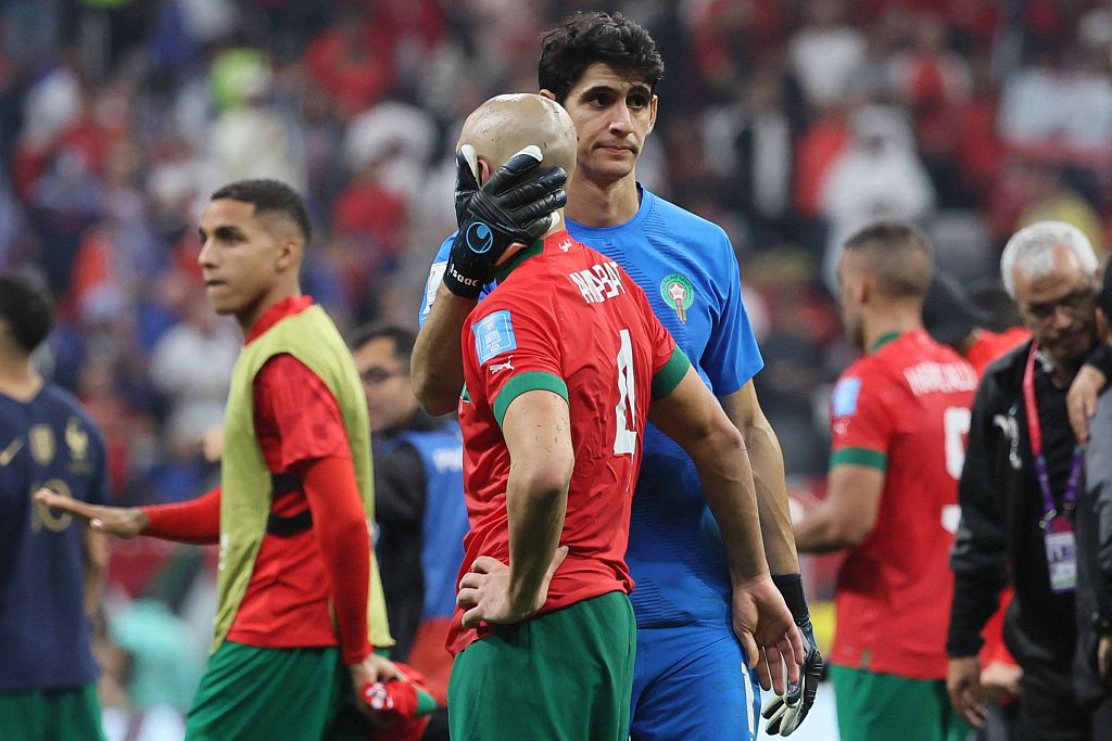 Morocco's goalkeeper Yassine Bounou comforts teammate Sofyan Amrabat after losing to France in the World Cup semifinal round, December 14, 2022. /CFP