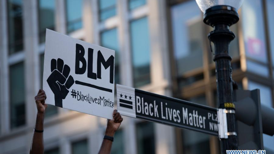 A protester holds a sign near the White House in Washington D.C., the U.S., June 8, 2020. /Xinhua