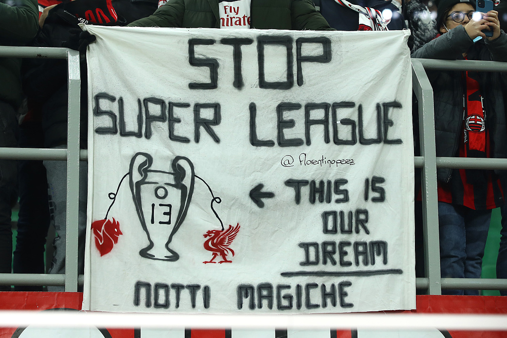 A football fan holds a banner that opposes the European Super League during the UEFA Champions League between AC Milan and Liverpool at Stadio San Siro in Milan, Italy, December 7, 2021. /CFP