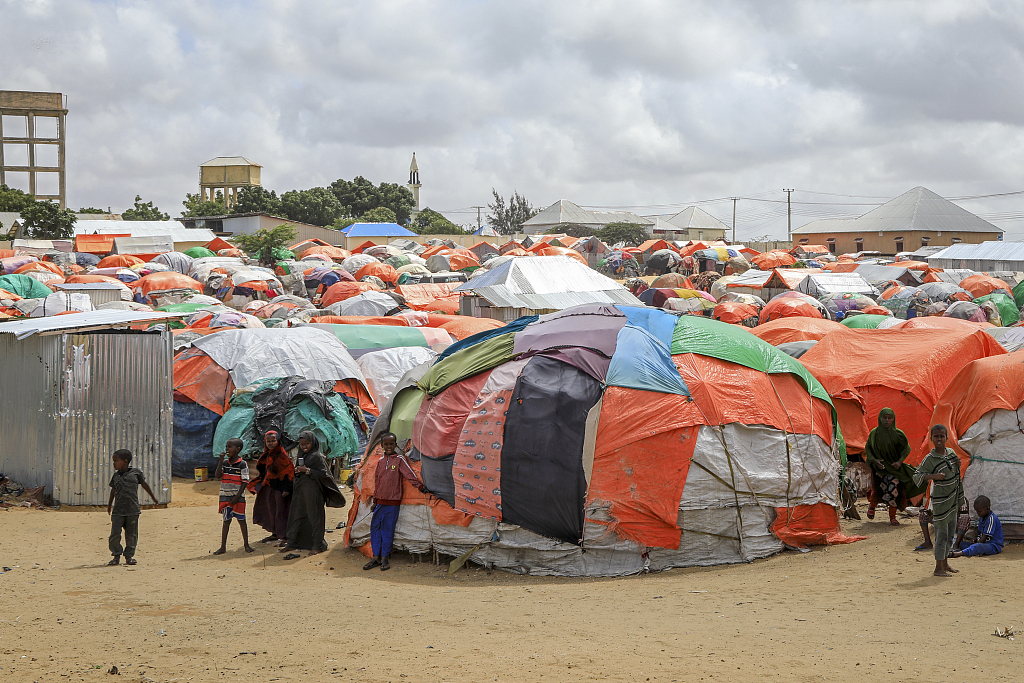 Somali children who fled drought-stricken areas stand by their makeshift shelters at a camp for the displaced on the outskirts of Mogadishu, Somalia, September 3, 2022. /VCG 