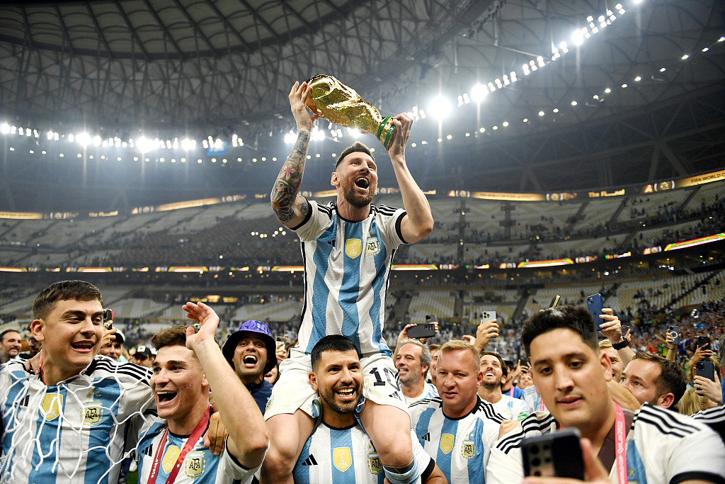 Former Argentine forward Sergio Aguero carries Lionel Messi (top) on the shoulder after winning the Qatar World Cup title in Lusail, Qatar, December 18, 2022. /CFP 