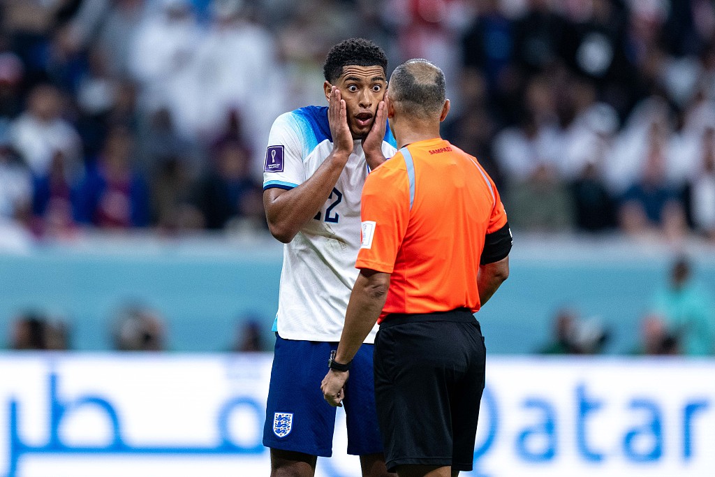 Jude Bellingham (L) of England faces a referee during the quarterfinal between England and France at Al Bayt Stadium in Al Khor, Qatar, December 10, 2022. /CFP 