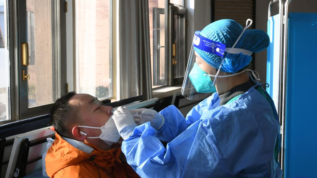 A medical staff administers a second booster dose of COVID-19 vaccine for a resident through nose at a temporary vaccination site in Haidian District, Beijing, capital of China, December 17, 2022. /Xinhua