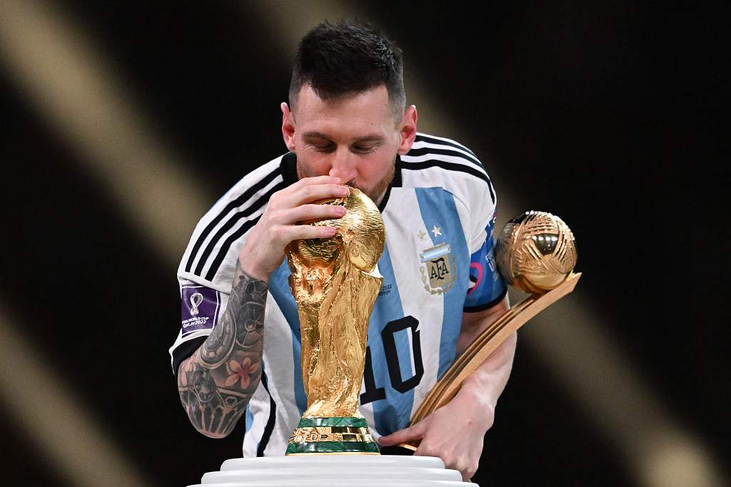 Lionel Messi of Argentina kisses the FIFA World Cup Trophy with the Golden Ball award in his hand after winning the final against France in Lusail City, Qatar, December 18, 2022. /CFP