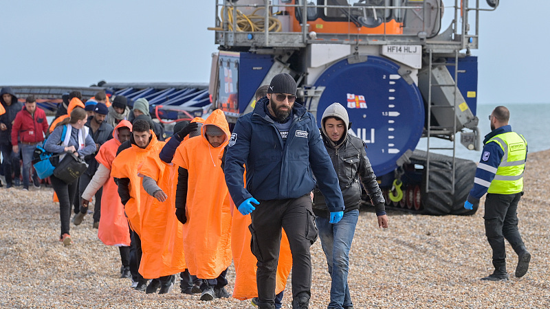 Migrants being helped ashore from a packed lifeboat by the border force and police officers are taken to Dungeness beach in Kent, UK, October 12, 2022. /CFP