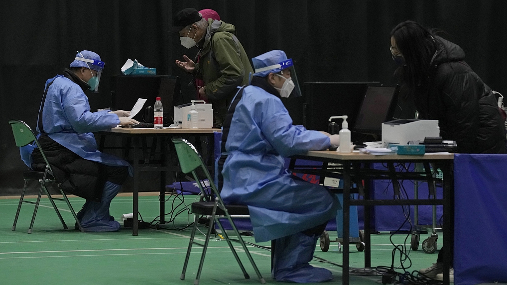 Medical workers attend to visitors at a fever clinic converted from a gymnasium in Beijing, December 17, 2022. /CFP