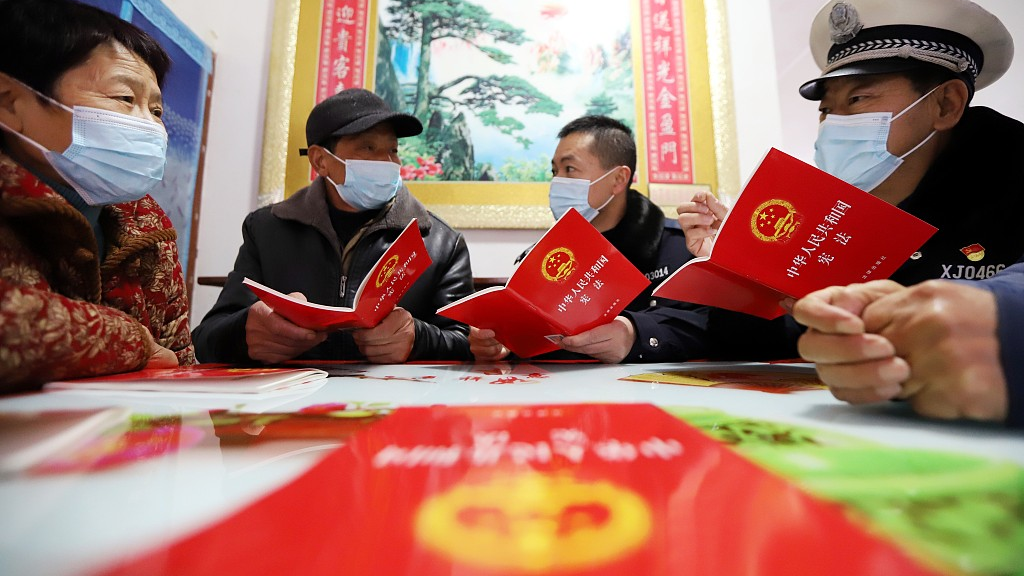 Community workers teach the 1982 Constitution of the People's Republic of China to local residents in Wuhu, southeast China's Anhui Province, December 4, 2022. /CFP