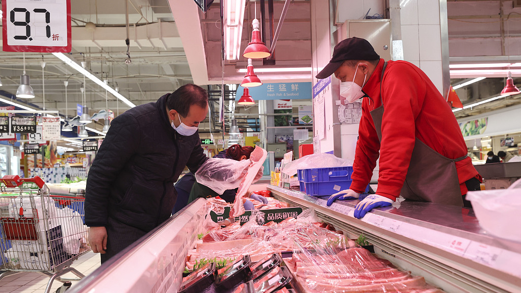 A customer shops for pork at a grocery store, Taiyuan, Shanxi Province, China, December 9, 2022. /CFP