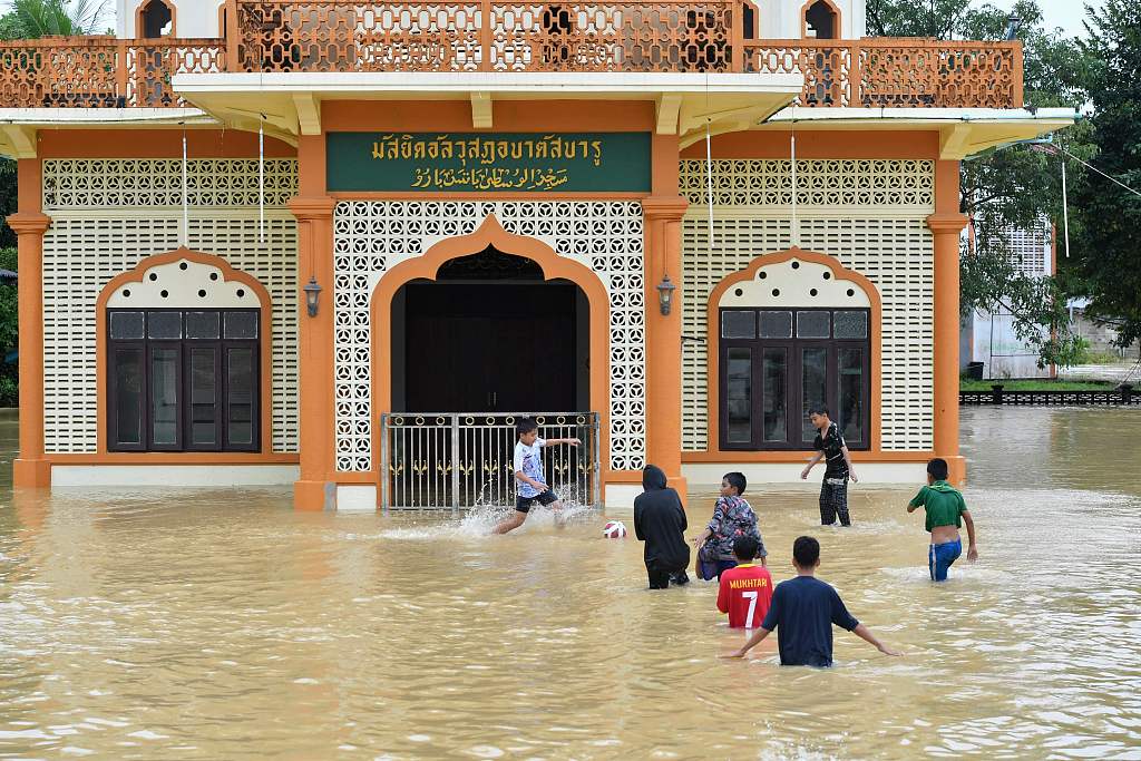 After heavy rain, children played with water around a flooded mosque in Manang Taylor Village, Taogong Province, Thailand, December 19, 2022. /CFP