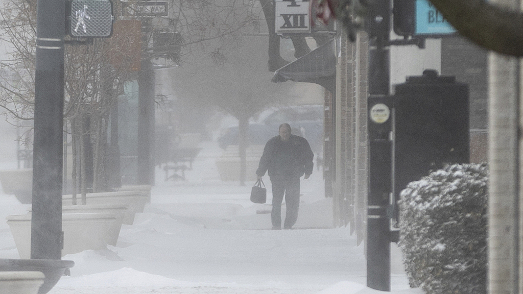 A pedestrian walks through downtown Wichita, Kansas, during a snow squall, December 22, 2022. /CFP