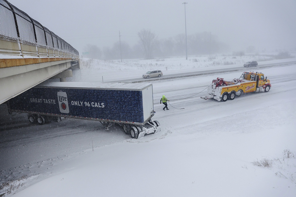 A worker prepares to tow a jackknifed semi truck on U.S. 131 south in Wyoming, Michigan, December 23, 2022. /CFP
