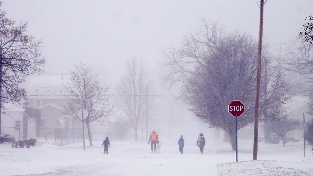 A family walks through a neighborhood during a winter snowstorm affecting most of the U.S., in Flint, MI on December 23, 2022./CFP
