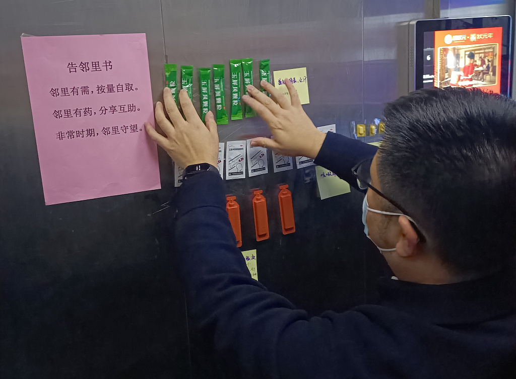 Zheng Yang, a resident in Lanjiang Apartment, divides antipyretics and cough medicines into small portions and puts them in elevators, so that neighbors who are in urgent need of medicines could pick them up, in Hangzhou, Zhejiang Province, China, December 22, 2022. /CFP