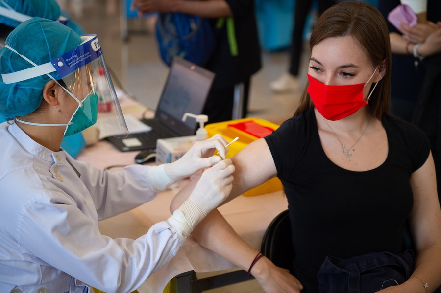 A health worker administers a dose of COVID-19 vaccine to Anna Lujza Honecz from Hungary at a vaccination site in Tsinghua University, Beijing, capital of China, April 3, 2021. /Xinhua