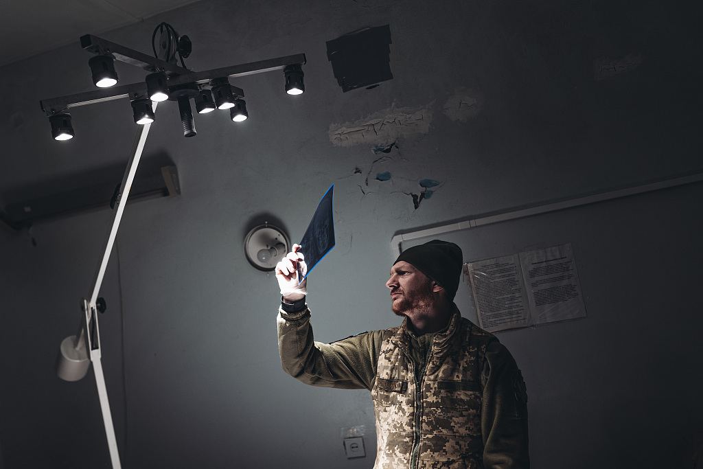 A doctor looks at an X-ray of a wounded soldier in a hospital on the Donbass frontline in Bakhmut on December 25, 2022. /CFP