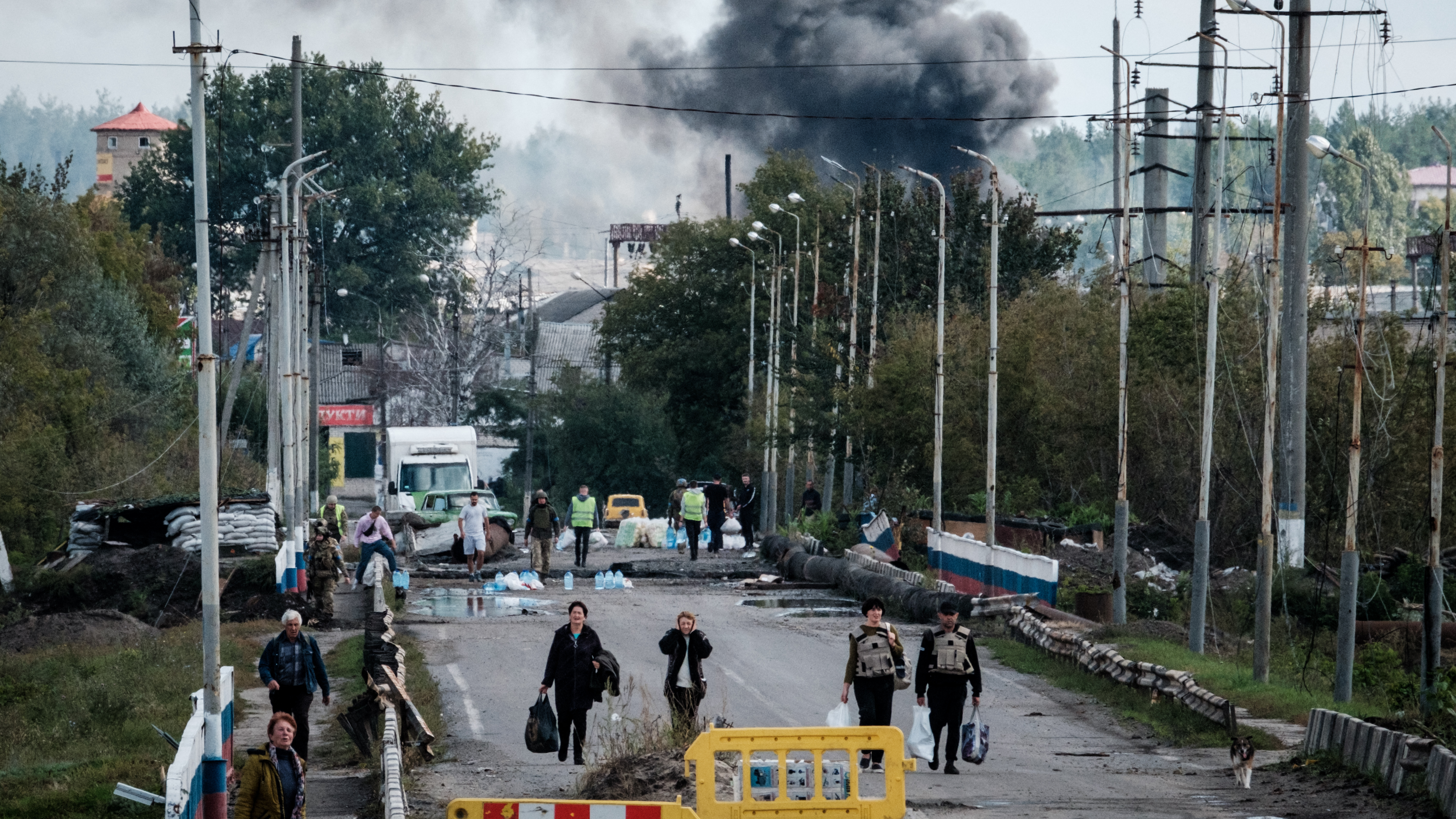 People seen fleeing after a Russian attack on a bridge over the Oskil River in Kupiansk, in the Kharkiv region. /AFP