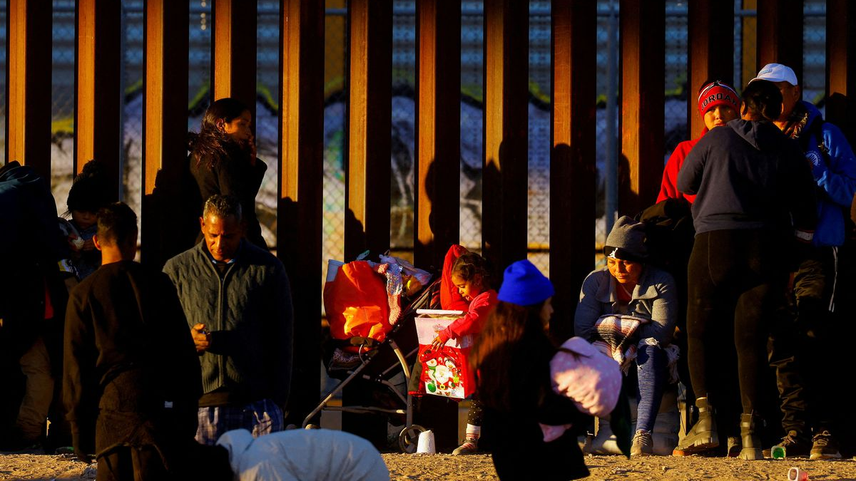 A migrant girl holds a Christmas present, as she queues with her family near the border wall to request asylum in El Paso, Texas, U.S., December 25, 2022. /Reuters