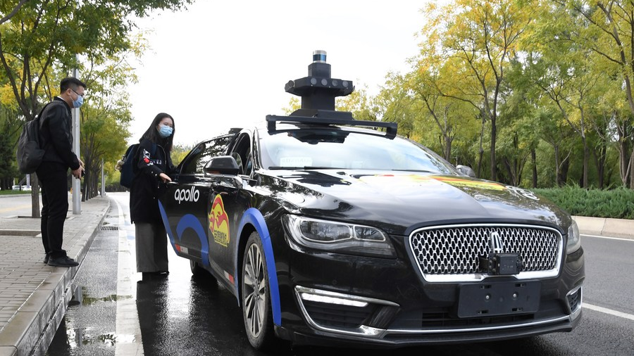 A woman takes a self-driving taxi at an appointed location on the Daoxianghu Road in Haidian District of Beijing, capital of China, October 14, 2020. /Xinhua