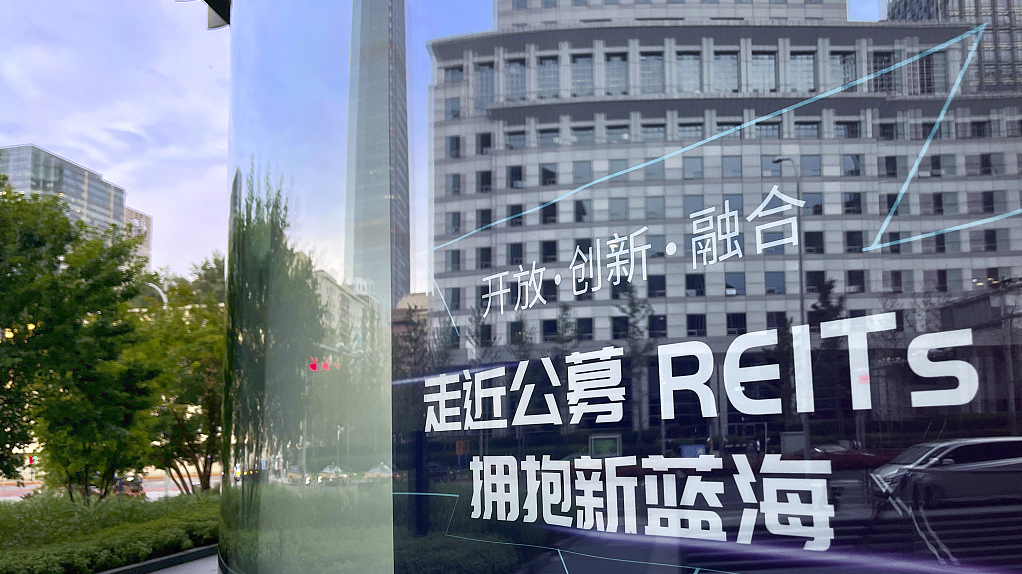 A poster promoting REITs is seen on the windows of a brokerage company on Guanghua Road, Beijing, July 9, 2022. /CFP