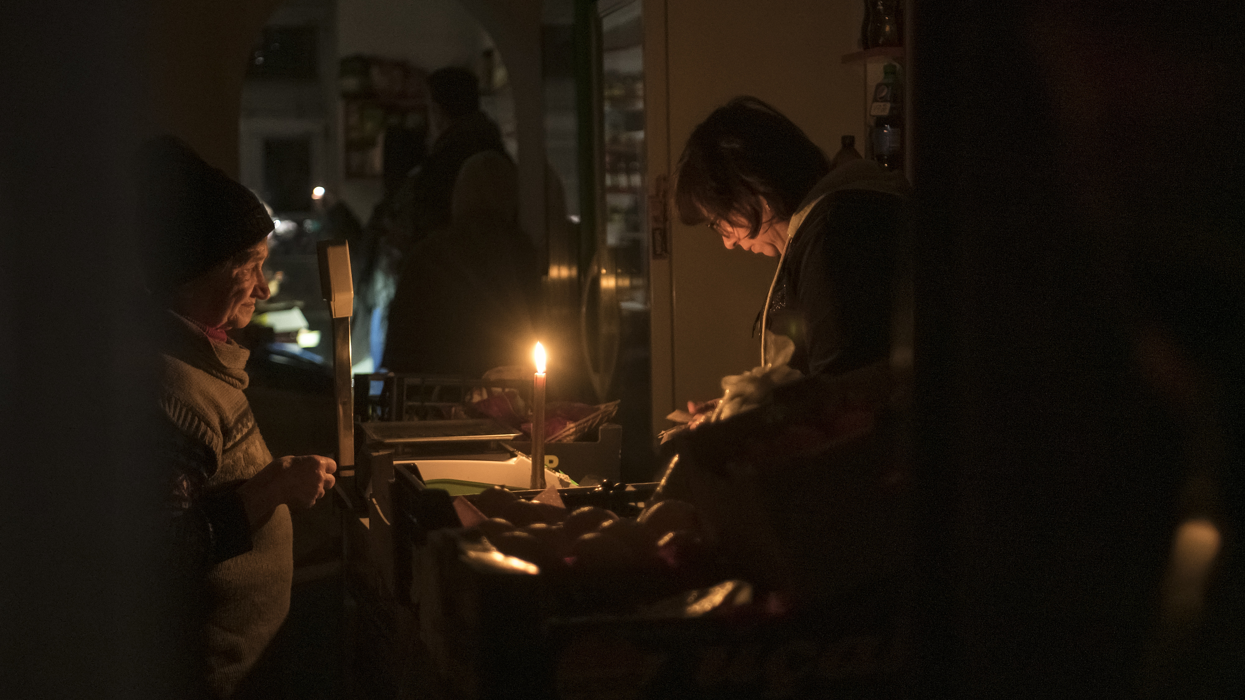 People in a shop that serves customers by candlelight in Lviv, Ukraine, November 15, 2022. /CFP