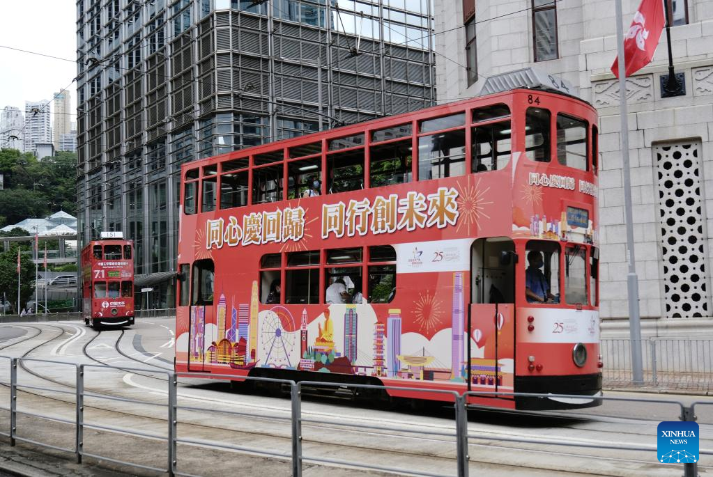 A bus painted with posters marking the 25th anniversary of Hong Kong's return to the motherland runs in Hong Kong, south China, June 30, 2022. /Xinhua